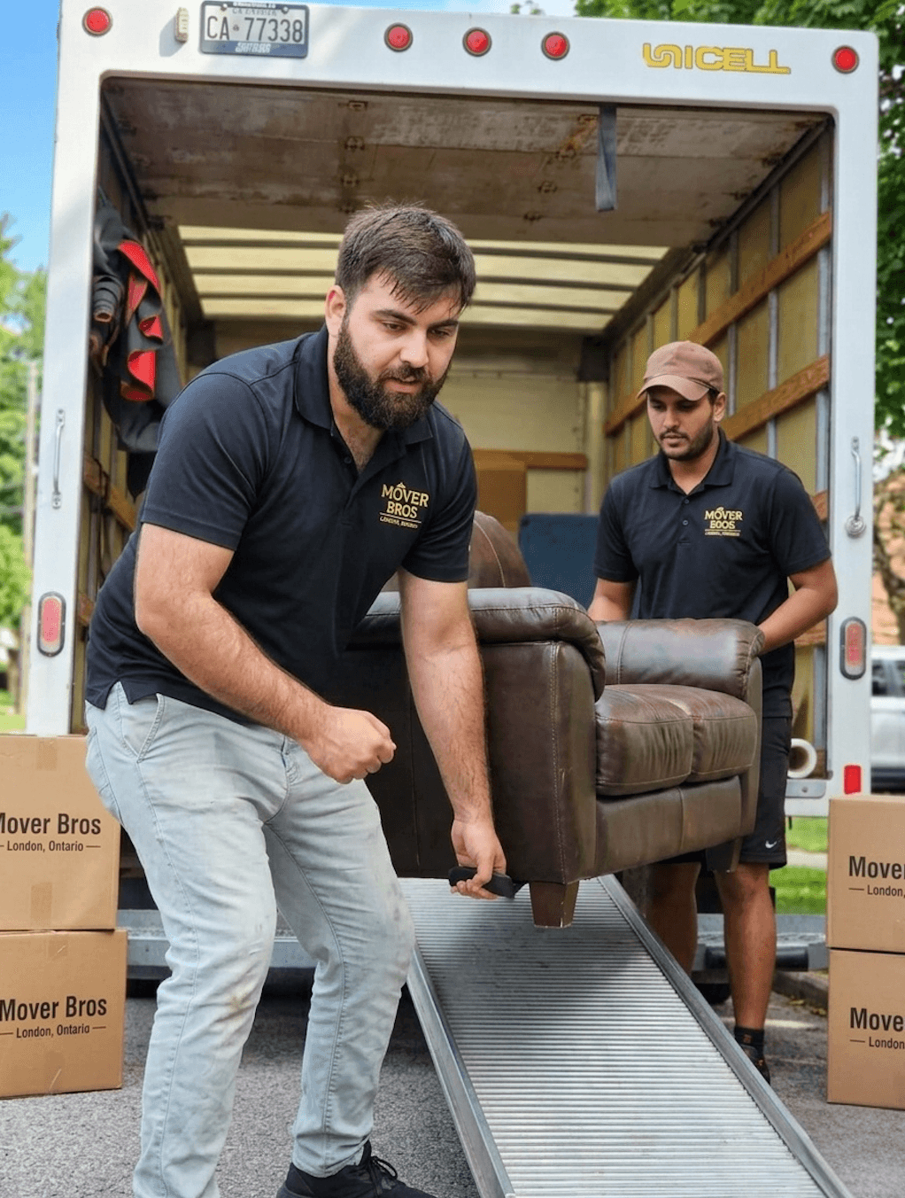 Two Mover Bros movers carefully carrying furniture off the truck